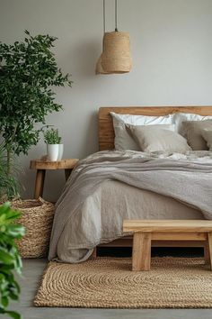 a bed sitting next to a plant in a bedroom on top of a wooden floor