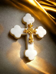 a white cross with gold accents sitting on top of a table