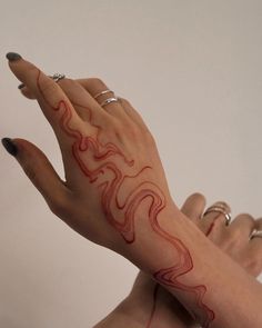 two hands with red and white designs on them