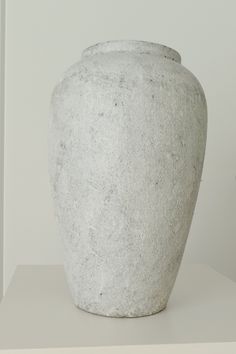 a white vase sitting on top of a table