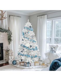 a white christmas tree decorated with blue ornaments