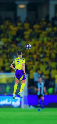 a soccer player jumping up in the air to catch a ball with his head and legs