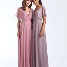 two women standing next to each other in long dresses