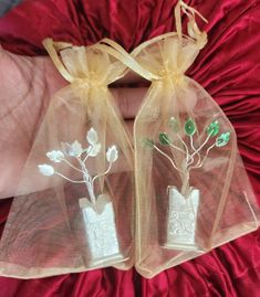 two organ bags with flowers in them on a red cloth covered tablecloth and someone holding the bag