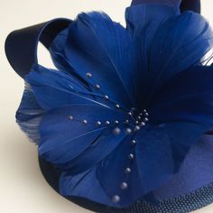 The Royal Blue fascinator pillbox hat - vintage, glamours and European inspired! The Royal Blue fascinator is about 5 inches wide & adorned with elegant royal blue ribbon, beading, feathering and a flower. An alligator clip at the base of the fascinator holds the piece in place. All of our items are handmade by a member of our shop. Our crowns, tiaras and jewelry are made of a thicker plating that contains real silver or gold and is nickel free. Our rhinestones are real European rhinestones Blue Curved Brim Headpiece For Royal Ascot, Adjustable Blue Mini Hats For Weddings, Adjustable Blue Mini Hat For Wedding, Blue Short Brim Fascinator For Wedding, Blue Mini Hat With Short Brim For Wedding, Blue Short Brim Headpiece For Evening, Adjustable Blue Headpiece With Curved Brim, Blue Party Costume Hats, Blue Adjustable Fascinator For Gift