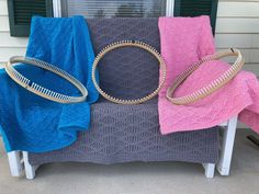 three different colored towels sitting on top of a bench