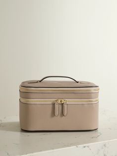 While taking cues from '50s styles, Smythson's cosmetics case feels so timeless. It's made from the house's heritage 'Panama' textured-leather, which is lightweight but resilient, and comes fully lined in cotton. Inside you'll find a pull-out mirror and designated pouches for lotions and serums. Use it as a centerpiece on your dressing table between trips. Luxury Rectangular Cosmetic Bag For Formal Use, Luxury Rectangular Cosmetic Bag For Formal Occasions, Luxury Formal Rectangular Cosmetic Bag, Elegant Travel Cases With Interior Card Slots, Elegant Rectangular Cosmetic Bag For Business, Classic Rectangular Formal Cosmetic Bag, Classic Rectangular Case, Elegant Rectangular Case With Smooth Grain, Elegant Cream Cosmetic Bag For Travel