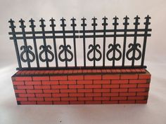 a brick planter with wrought iron fencing on top