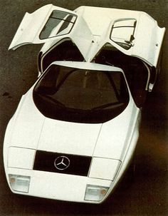 an old photo of a white sports car with its hood up and the door open