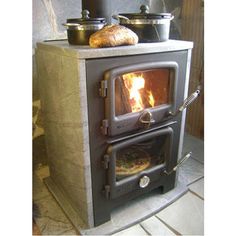 an old fashioned wood burning stove with some bread on it's burner and oven door open