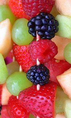 fruit skewers filled with fresh berries, kiwis, and strawberries