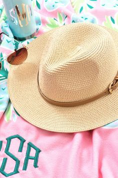 This natural straw fedora hat is the perfect way to top off your look. Whether you're in the sun and want to shade your face or if you just want to add a little something to your look, this fedora hat is the perfect accessory! This fedora hat features a soft brim and indented crown. Available with a black twisted, brown, or pink gingham belt accent. For other ways to complete your look, check out our monogrammed jewelry and monogrammed tote bags. Chic Fedora Hat For Travel, Chic Travel Fedora Hat, Chic Straw Fedora Panama Hat, Adjustable Fedora Panama Hat For Travel, Chic Straw Fedora With Upf 50+, Adjustable Flat Brim Fedora For Vacation, Travel Fedora Panama Hat, One Size Fits Most, Chic Brimmed Fedora For Travel, One Size Fits Most Fedora Panama Hat For Travel