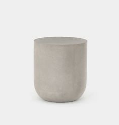 a concrete vase sitting on top of a white surface with no one around it,