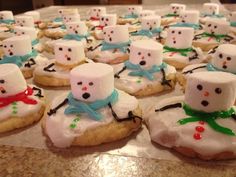 cookies decorated with frosting and marshmallows are arranged in the shape of snowmen