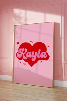 a pink frame with the word kayla on it in front of a pink wall