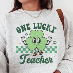 How cute is this retro St. Patricks Day sweatshirt? This crewneck is sure to be loved by teachers and students for years to come. This is the perfect St. Patrick's Day gift for that one lucky teacher in your life! ----------------------------------------------------------------------------------------------------------------------- Handmade with production assistance SIZING Unisex - depends on each shirt type (see size chart for more details). It is recommended to reduce your size for a more fem Cute Letter Print Sweatshirt For School, Cute Green Sweatshirt With Letter Print, Green Crew Neck Sweatshirt For School, Crew Neck Sweatshirt With Screen Print For School, Green Cotton Sweatshirt For School, Plus Size Teacher Outfits, Plus Size Teacher, Retro St Patricks Day, St Patrick's Day Outfit