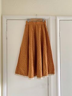 "Vintage 1970s Handmade Costume Cotton Mustard Floral Pattern Skirt. The skirt does up at the side with poppers. So beautiful and unique! Long flare style. Lace trim at the hem. Was made as a costume for a theatre  ~ handmade so might not be perfect.  Would fit around UK size 8 Skirt Measurements - Waist: 25\" Hips: 36\" Length: 32.5\" How to Care: Hand Wash When you unpack your order, hang it up and let it relax to let the creases drop out, either steam it or gentle press on the reverse side of Orange Cotton Skirt For Fall, Brown Cotton Maxi Skirt With Lined Skirt, Brown Cotton Maxi Skirt With Lining, Brown Vintage Tiered Skirt, Vintage Brown Tiered Skirt, Vintage Cotton Flared Skirt Bottoms, Vintage Cotton Flared Skirt, Vintage Cotton Brown Skirt, Vintage Tiered Skirt For Fall