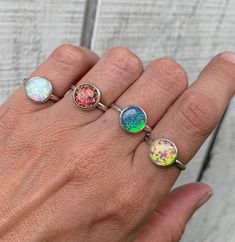 Choose your color for this simulated opal ring that has been set in sterling silver with a handmade ring band made from sterling silver half dome wire. Flecks of green, orange, pink, white, and blue shine from the opal. The handmade bezel is fine silver. The opal cabochon is 10mm in size.  Made to order!  Opal is the birthstone for October! Pink Opal Ring, October Birthstone Ring, Romantic Rings, October Birthstone Rings, Malachite Rings, October Birthstone, Pink Ring, Half Dome, Opal Ring