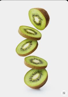 kiwi slices falling into the air on a white background