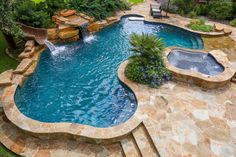 an outdoor swimming pool with steps leading up to it and a waterfall in the middle