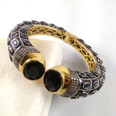 This Listing is for 1 Piece Beautiful Black Onyx, Sapphire & CZ Hydro Gemstone 24k Gold Plated Cuff Bangle Bracelet Jewelry Gemstone: Black Onyx, Sapphire & CZ Metal : Brass Style : Cuff Bracelet Size : Cuff Adjustable Size Plating : 24k Gold Plated & Black Oxidize Color : Yellow,White, Black Note : We Ship Parcel Via India Post Economy Shipping It's Take 20 To 25 Days To Arrive. Check my other items frequently. I will be adding to the inventory regularly. Be sure to visit my shop to Formal Jeweled Round Bangle, Round Gemstone Bangle For Party, Hand Set Round Cuff Bracelet For Anniversary, Formal Jewel Bangle Cuff Bracelet, Adjustable Jeweled Bangle For Formal Occasions, Formal Jeweled Cuff Bangle Bracelet, Party Bracelets With Stone Setting, Stone Set Bangle Bracelet For Party, Party Bangle Bracelet With Stone Setting