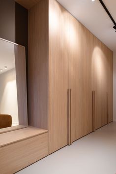 an empty room with wooden cabinets and white flooring