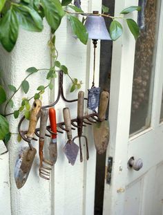 garden tools hanging from hooks on the side of a door