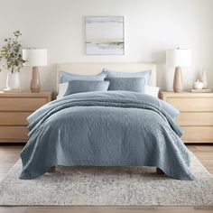 a bed with blue comforter and pillows in a bedroom