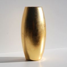 a gold vase sitting on top of a white table