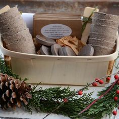 a wooden box filled with lots of different items next to a pine cone and red berries