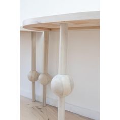 two wooden balls sitting on top of each other in front of a white wall and wood floor