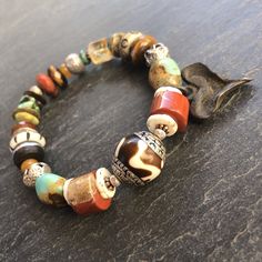 "Boho at its best!   This bracelet is perfect to wear with your Fall neutrals.. cream sweater and jeans, leather boots, a great dress as the weather gets cooler and into the holidays..  It is designed around a gorgeous Nepali Silver capped Horn bead from Tibet.  This is combined with a rustic eclectic Fall mix of beads and stones including Ostrich Shell, Red Jasper, Genuine Hubei Turquoise, carved bone beads, faceted Citrine and a silver rimmed ebony wheel.  An artisan blackened bronze rustic he Southwestern Natural Stones Beaded Bracelet Gift, Multicolor Artisan Bracelets For Meditation, Southwestern Gemstone Beads Bracelet For Healing, Southwestern Gemstone Beads Healing Bracelet, Southwestern Style Healing Gemstone Beads Bracelet, Handmade Southwestern Healing Bracelets, Southwestern Gemstone Beaded Bracelets For Healing, Bohemian Crystal Bracelet With Large Beads For Gift, Spiritual Turquoise Beaded Bracelets With Large Beads