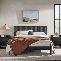 a bedroom with a bed, nightstands and windows