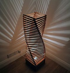 a wooden sculpture sitting on top of a hard wood floor next to a white wall