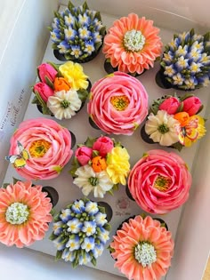 the cupcakes are decorated with colorful flowers