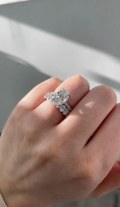 a woman's hand with a diamond ring on it