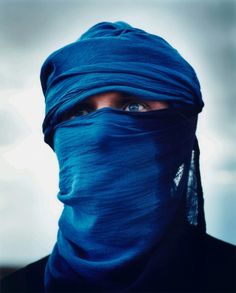 a man wearing a blue head covering over his face