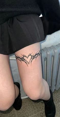 a woman's legs with tattoos on them, and the word love written in barbed wire