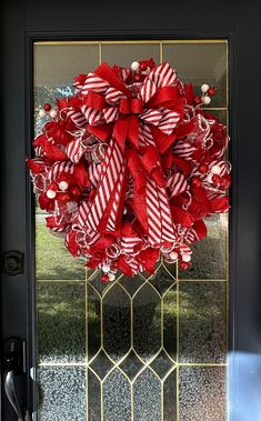 a red and white wreath hanging on the front door