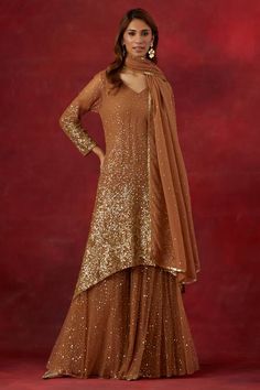 Rust asymmetric hem woven kurta with gold sequin hand embroidered in scattered ombre pattern. Comes with coordinating sequined sharara and matching dupatta. - Aza Fashions Gold Sequin Dress For Diwali, Gold Palazzo Set With Mirror Work And Traditional Drape, Gold Georgette Palazzo Set For Party, Gold Sharara With Sequins In Traditional Drape, Gold Sharara With Sequins And Traditional Drape, Traditional Drape Gold Sharara With Sequins, Gold Georgette Sequin Dress, Designer Gold Dupatta With Sequins, Gold Sequined Dupatta For Designer Wear