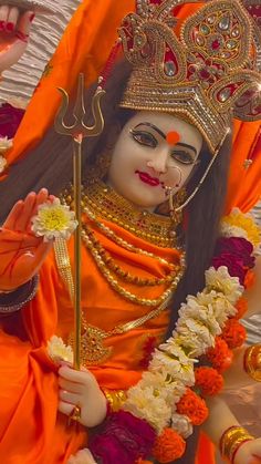 an idol is dressed in orange and gold