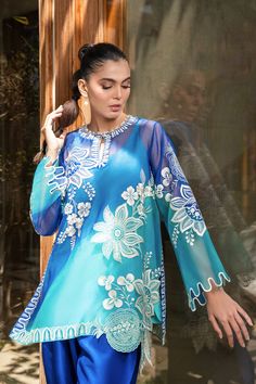 A blue ombre organza shirt is delicately rendered with bold ivory embroidery in a floral and fruit imagery. Featuring a keyhole neckline and scalloped sleeves, the shirt is paired with a royal blue rawsilk shalwar. Model Height is 5'9 and Shirt length is 32" Eid Organza Blouse With Intricate Embroidery, Summer Organza Kurta For Designer Wear, Blue Summer Lawn Suit With Straight Kurta, Elegant Blue Blouse Piece With Intricate Embroidery, Blue Summer Kurta With Dupatta, Summer Blue Kurta With Dupatta, Elegant Blue Blouse With Chikankari Embroidery, Blue Semi-stitched Kurta For Summer, Blue Summer Lawn Suit With Chikankari Embroidery