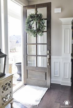 a door with a wreath on it in front of a window