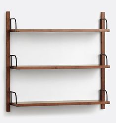 two wooden shelves with metal handles on each shelf, against a white wall behind them