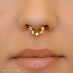 a woman's nose with a gold nose ring in the shape of an occupant