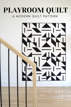 a black and white quilt hanging on the wall next to a stair case with text that reads playroom quilt a modern quilt pattern