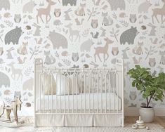 a baby's room with a white crib and wallpaper