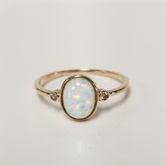 Thanks for shopping our vintage estate store. We tend to sell well below wholesale and truly hope you enjoy all of our items. Many of the items are one of a kind, so please enjoy scrolling through the pictures and hopefully something will catch your eye. Spots are from the camera or reflections. Estate 14k yellow gold created blue 1ct opal .02ct cz diamond cocktail ring.  Just stunning.  Ring size: 10 Setting: 3/8" 10mm Band width: 1.5mm Weight: 1.37 grams You will love this ring. Marked 14k. Op Classic Oval Opal Ring With Bezel Setting, Classic Oval Bezel Set Opal Ring, Classic Round Cut Opal Birthstone Ring, Classic Opal Promise Ring With Bezel Setting, Oval Opal Ring For Anniversary, Classic Opal Oval Cabochon Ring For Promise, Classic Opal Oval Cabochon Promise Ring, Classic 14k Gold Opal Ring, Classic Oval Cabochon Opal Promise Ring