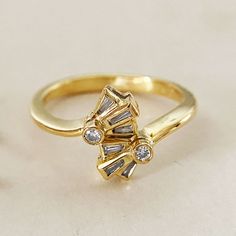 "A vintage 18K gold ring with baguette diamonds in art deco style.  The ring band is thick and has a bit of weight.  This did not originate in the Philippines.  It is stamped \"750\" which stands for 18K gold.  It is well-made, gently cleaned and in good condition. Measurements: US Ring Size: 6 Height: 0.47 inch  Width (widest part): 0.28 inch   Diamonds:                   0.05ct x 2 pcs (single cut)                  0.06ct x 6 pcs (baguette cut) Total Weight: 4.1g ------------------------------ Gold Coral Earrings, Baguette Cut Ring, Vintage Silver Brooch, 10k Gold Ring, Baguette Diamond Rings, Gold Cocktail Ring, Gold Cocktail, Baguette Diamonds, Gold Art Deco