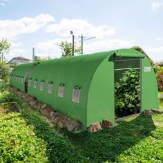 a large green structure sitting on top of a lush green field